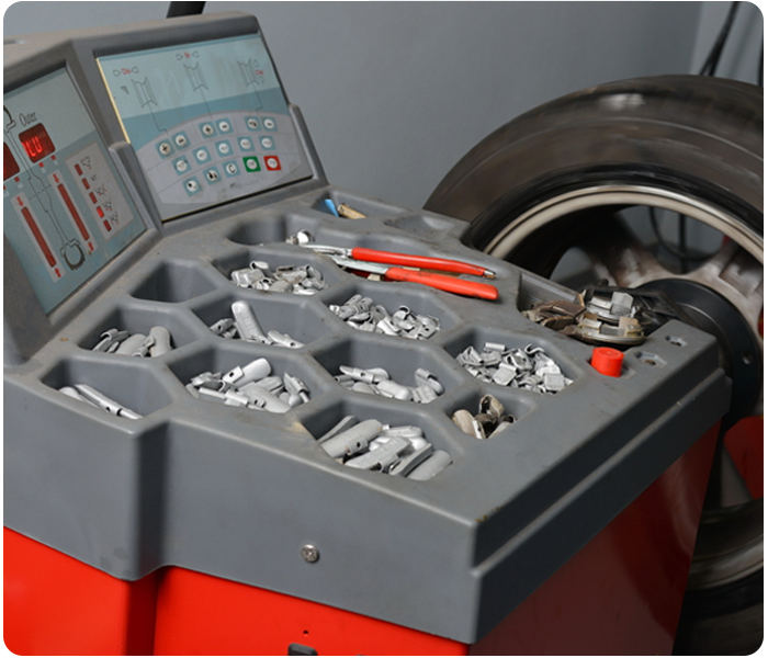 A balancing machine aligns car wheels, using balancing weights and settings for precise adjustments.